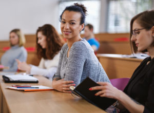 Stock photo of a woman in a classroom smiling.