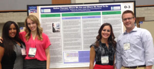 Photo of students and faculty standing in front of research poster