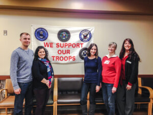 Photo of attendees standing in front of we support our troops banner