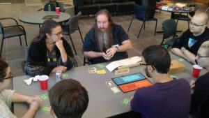 Photo of Dr. Blackstock and students playing a board game