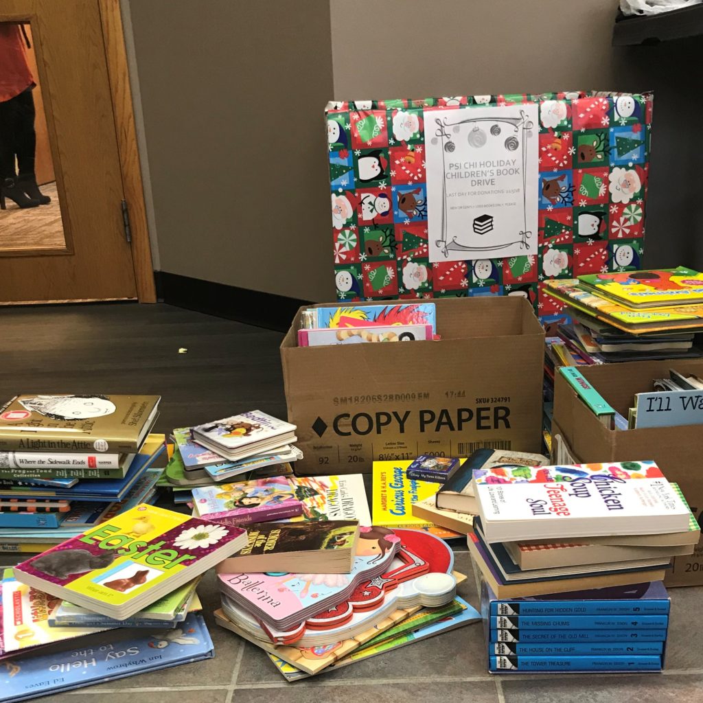 Photo of children's book piled for a drive benefiting Sanctum House