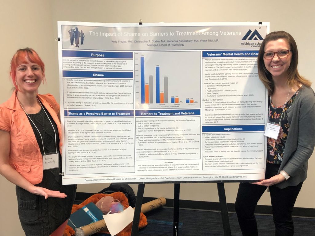 Rebecca Kaptansky and Kelly Frazee posing with their research poster "The Impact of Shame on Barriers to Treatment Among Veterans"