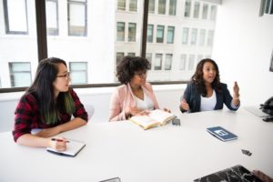 Stock photo of three professional women sitting at a table.