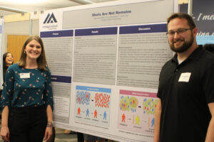 Mackenzie Glaros and Chris Corbin, PsyD Students pose with their research poster