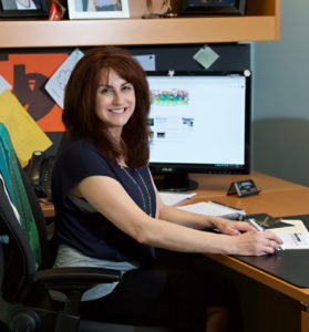 Photo of Diane Zalapi sitting at her desk in her office.
