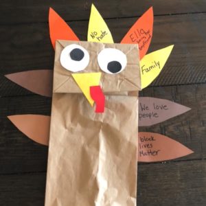 Photo of a paper bag turkey with feathers depicting the words "no hate" "Ella - being her boyfriend" "Family" "We love people" and "black lives matter"