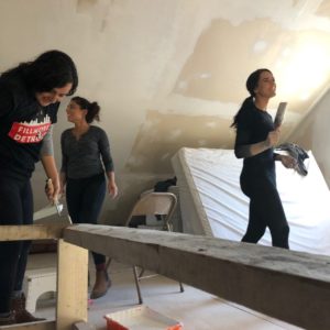 MSP students volunteering with IDEA on MLK Day in 2019. 3 women holding paint rollers in an unfinished room. 