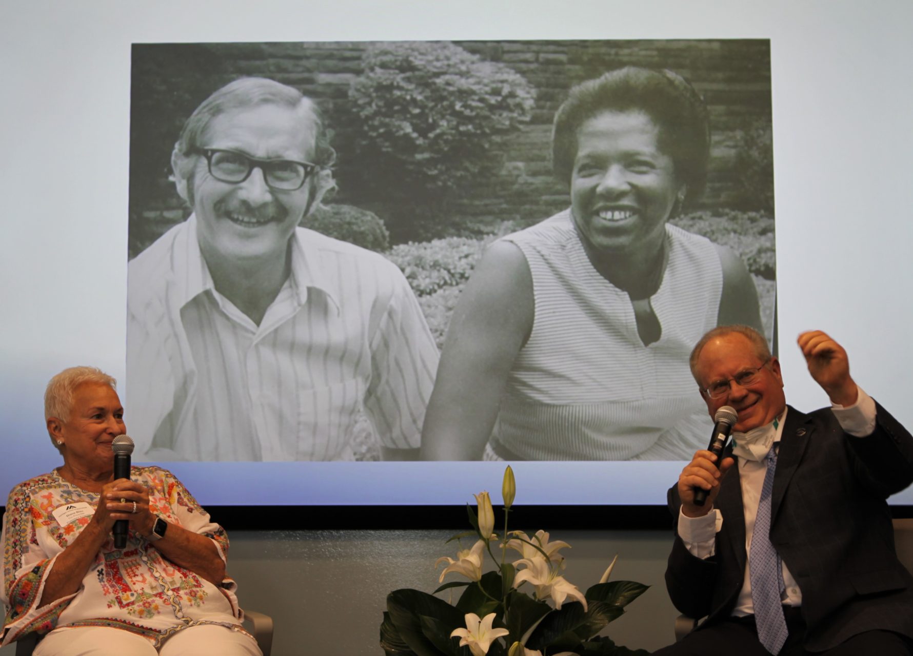 Photo of Co-founders Diane Blau and Bruce Douglass in front of a picture of Clark and Cereta