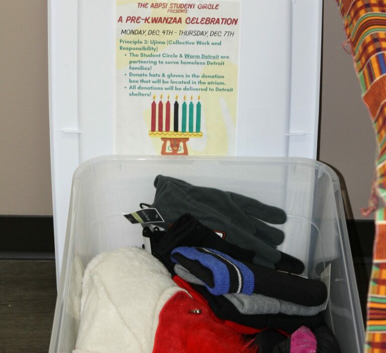 Photo of a box filled with winter clothing along with a graphic explaining the ABPsi hat and glove drive