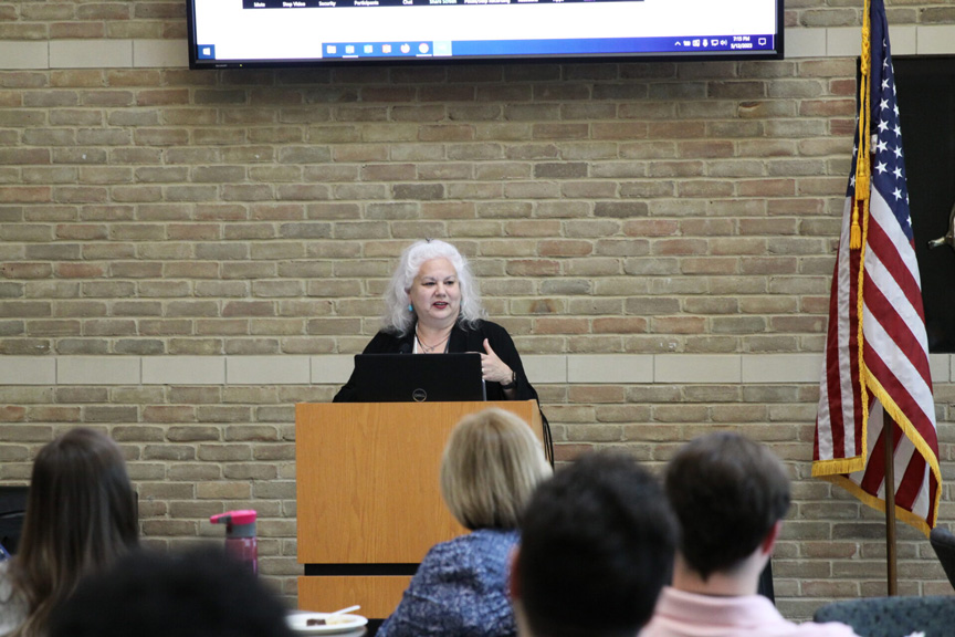 Dr. Gina Belton speaking at a podium