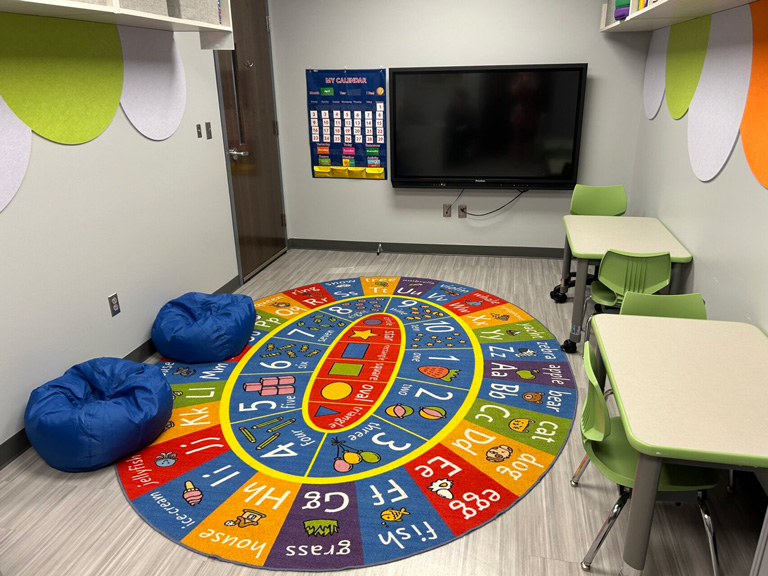 Photo of the MSP ABA room including a brightly colored alphabet and numbers rug