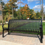 Photo of black bench with brick pavers under the bench