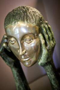 Photo of a sculpture of a head being held by hands