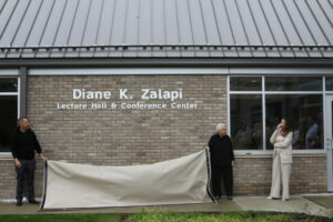 Drs. Spitsbergen and Blau pulling down a sheet revealing the naming of the building.