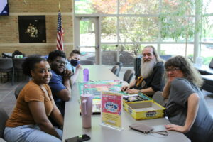 Photo of students, staff, and Dr. Blackstock posing for the camera during a game night.