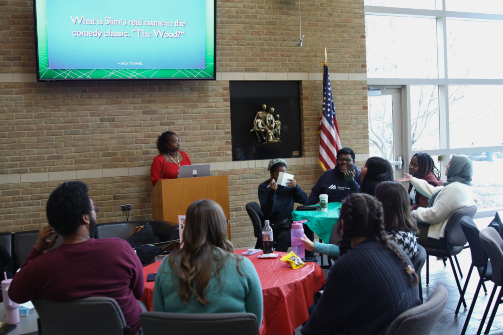 Photo of students sitting at tables playing a trivia game.