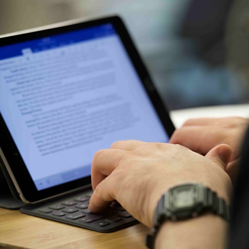 Photo of student's hands taking notes on a tablet