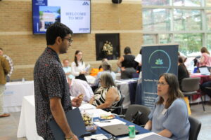 Photo of student talking to an employer at a table during career fair