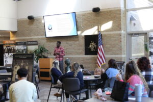 Joe Drew-Hundley presenting to students in the atrium
