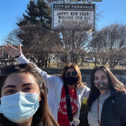 Photo of three students wearing masks in front a a City of Ferndale marque board
