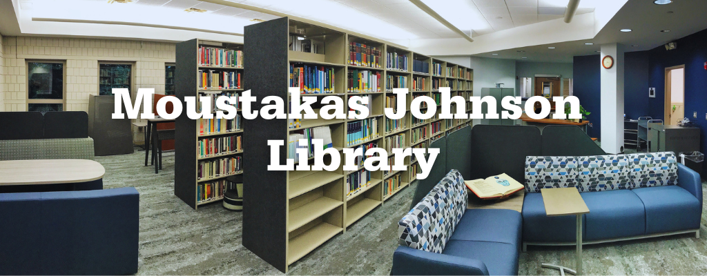 Photo of the Moustakas Johnson Library with couches in the foreground and bookshelves behind.